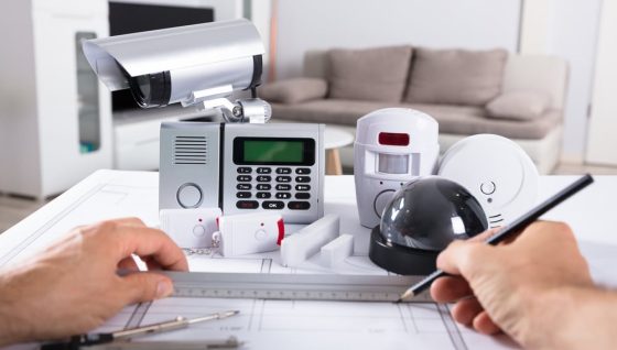 Human Hand Drawing Blueprint Near Security Equipments