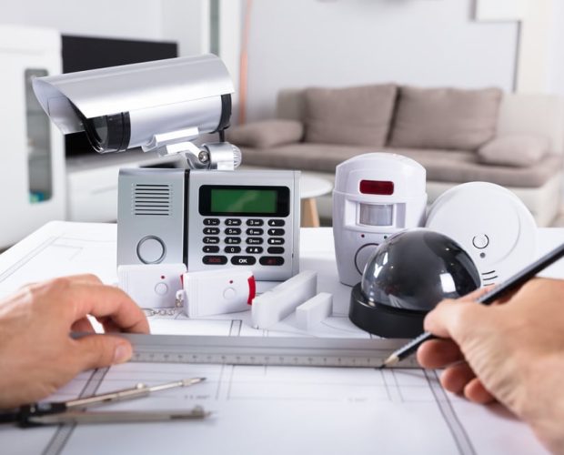 Human Hand Drawing Blueprint Near Security Equipments